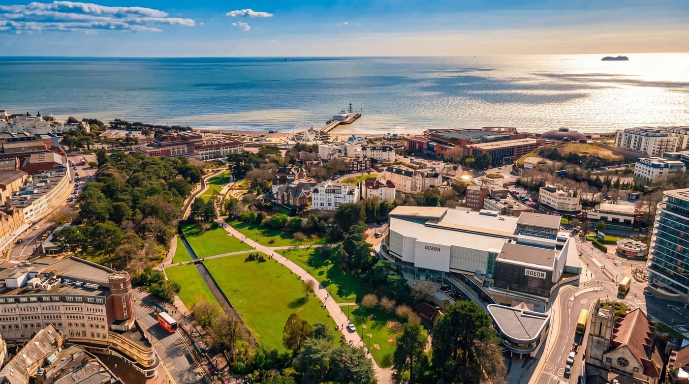 Aerial view of Bournemouth seafront showing the unbroken run of sand and promenade curving away below the cliffs